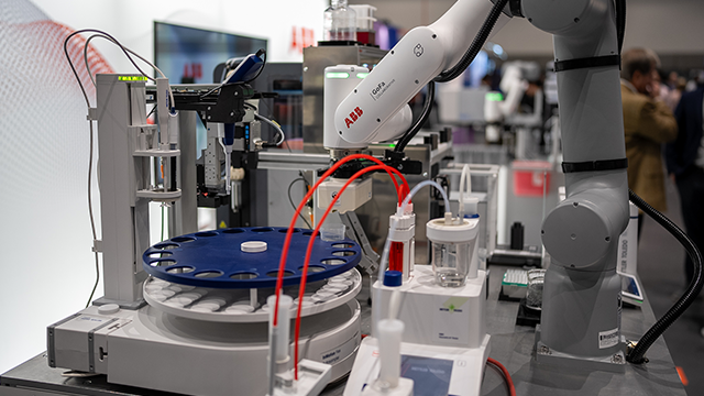 A robotic arm operates laboratory instrumentation