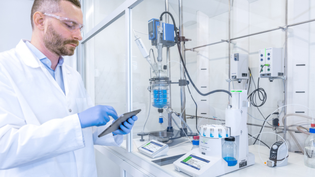 chemist working in lab with easysampler jacketed lab reactor rx-10 chemist working in lab with easysampler jacketed lab reactor rx-10