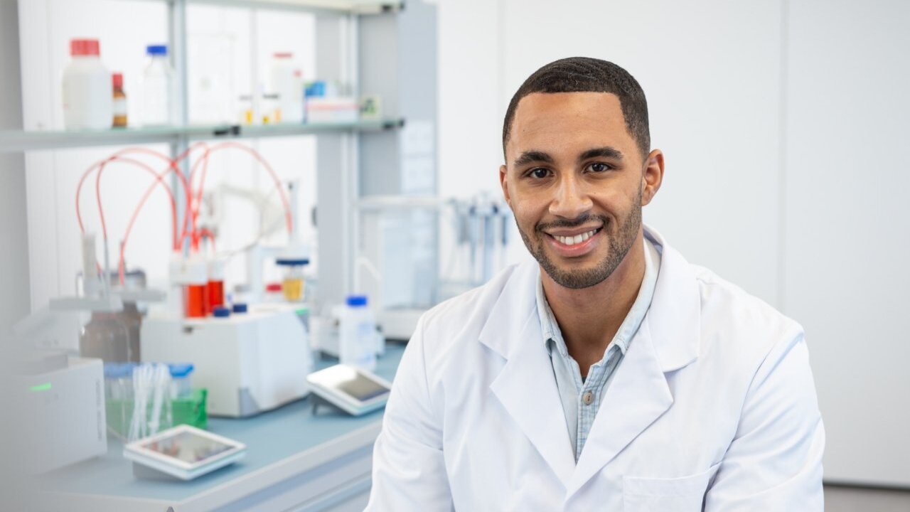 Male scientist sitting in a lab in front of a titrator