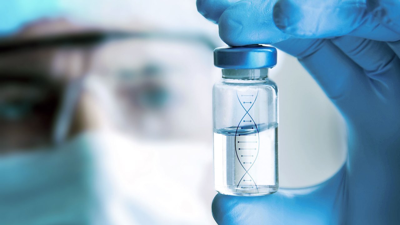 hand in blue glove holding a container