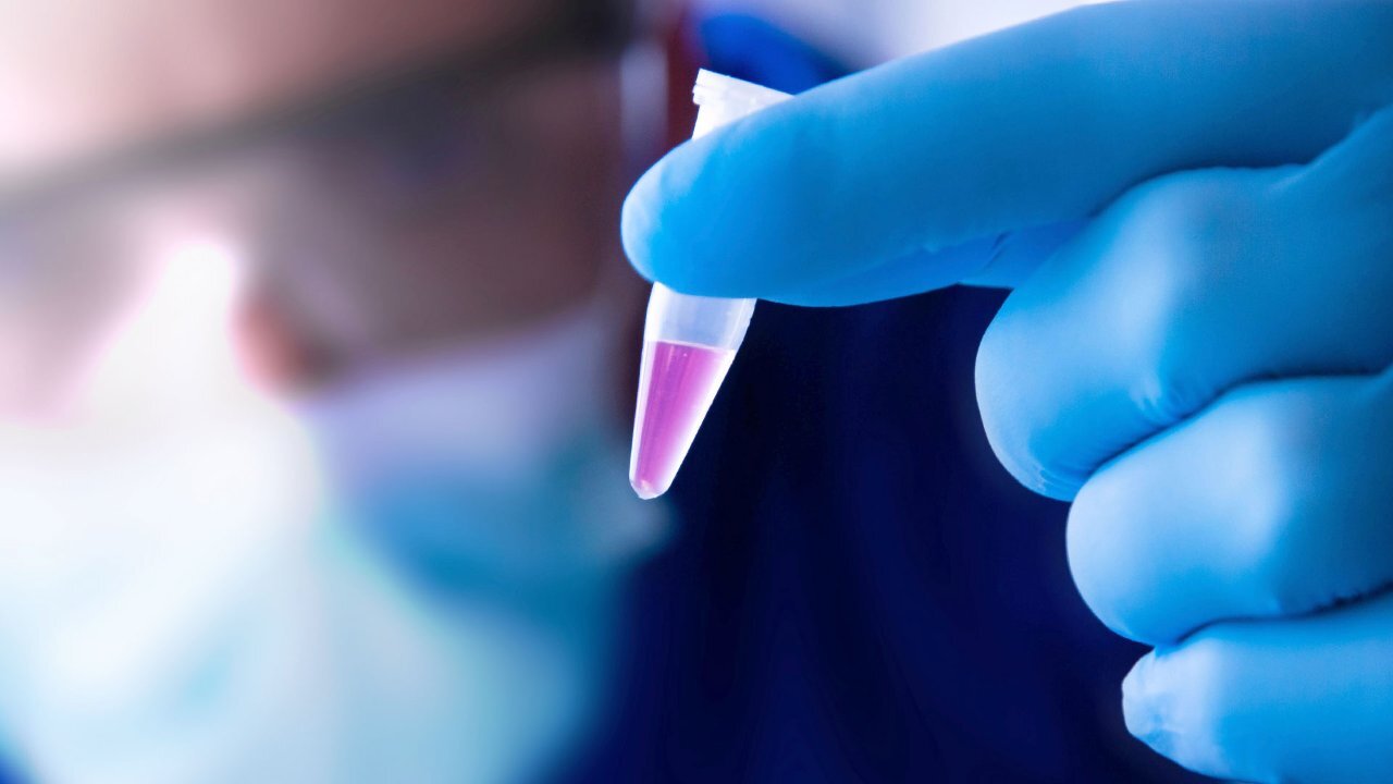 Scientist's finger holding a liquid
