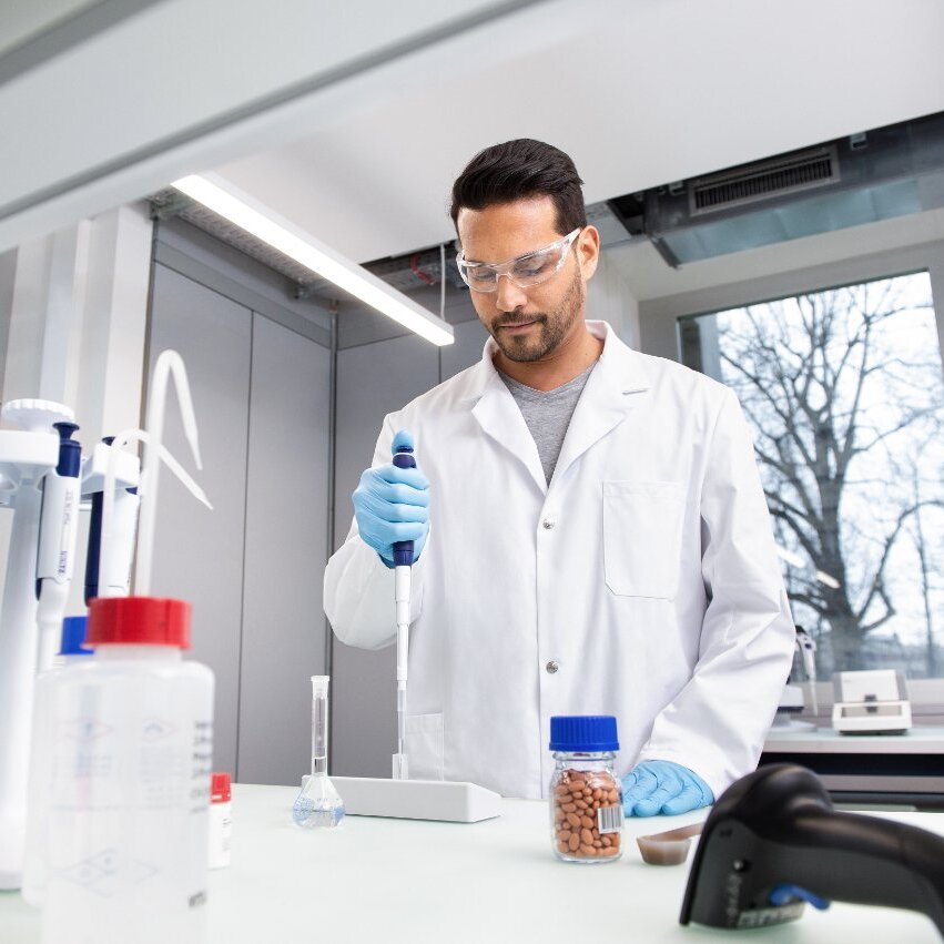 Researcher operating precise automated laboratory equipment