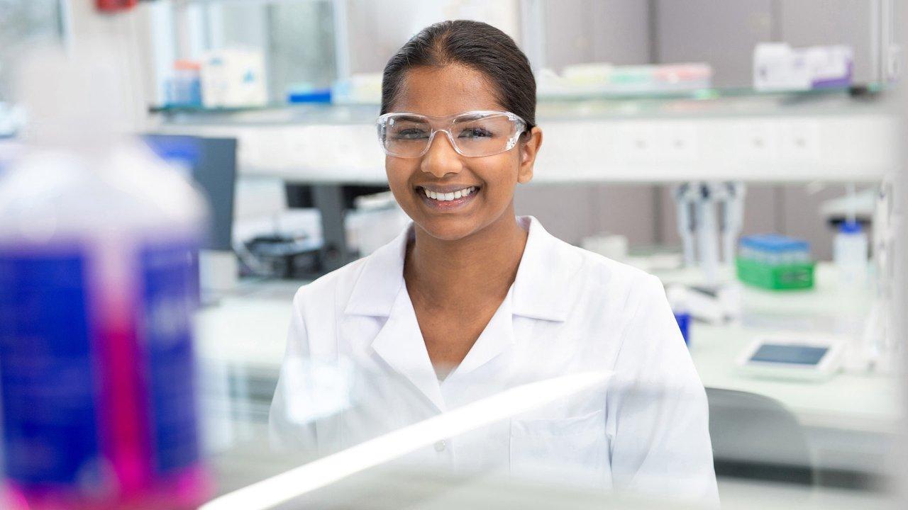 Female scientist smiling and wearing glasses