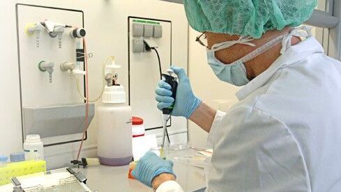 Scientist with pipette in science lab
