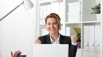 Woman on phone in front of laptop Woman on phone in front of laptop